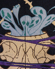 Close up of the skull, top half. Blue ghouls spill out of opening on the top of head.