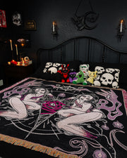 Seance spread on bed, with gothic pillows, plushies, and decor.
