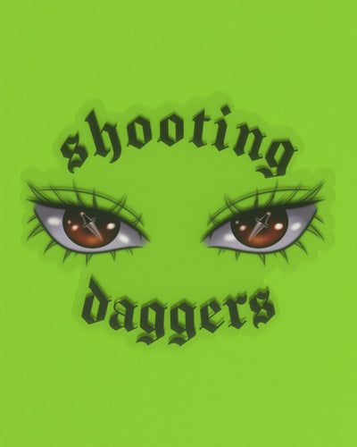 Clear sticker. Pair of red eyes with mini daggers reflected, in between text "Shooting Daggers" on the top and bottom.