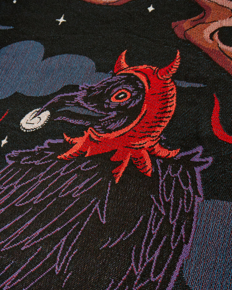 Temptation woven texture close up of the right crow wearing a devil bonnet while holding a white coin with a heart outline on it. 
