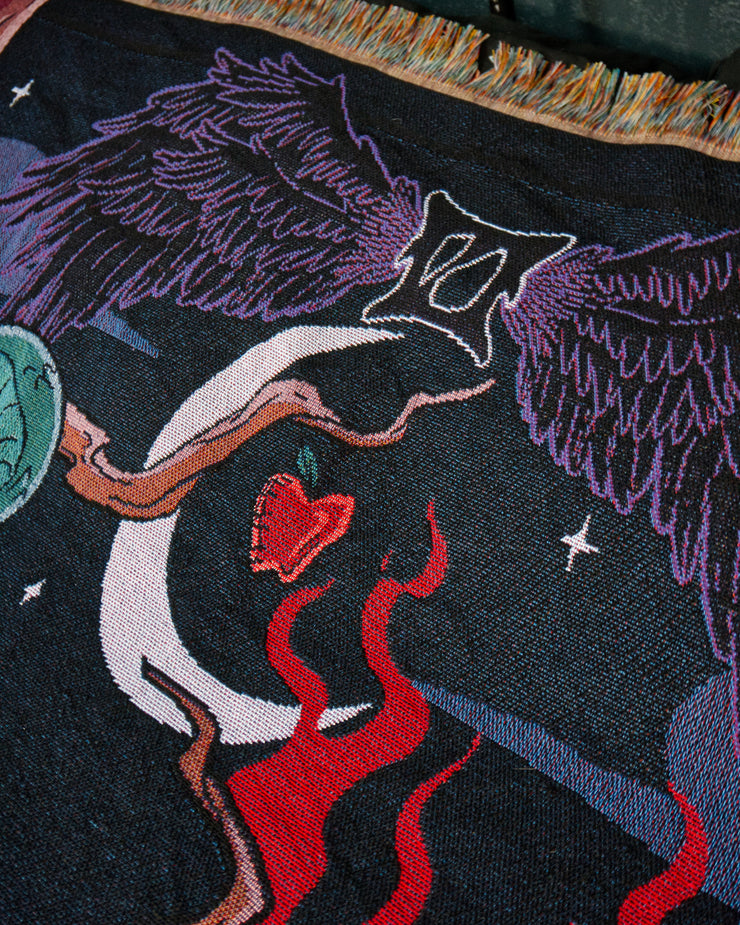 Temptation close up of roman numeral flanked by wings above a crescent moon with an apple in the center of it. 