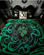 Underworld resting on a black bed with spider pillows against a white wall, surrounded by gothic room decor. Commission by LadyVampManor 